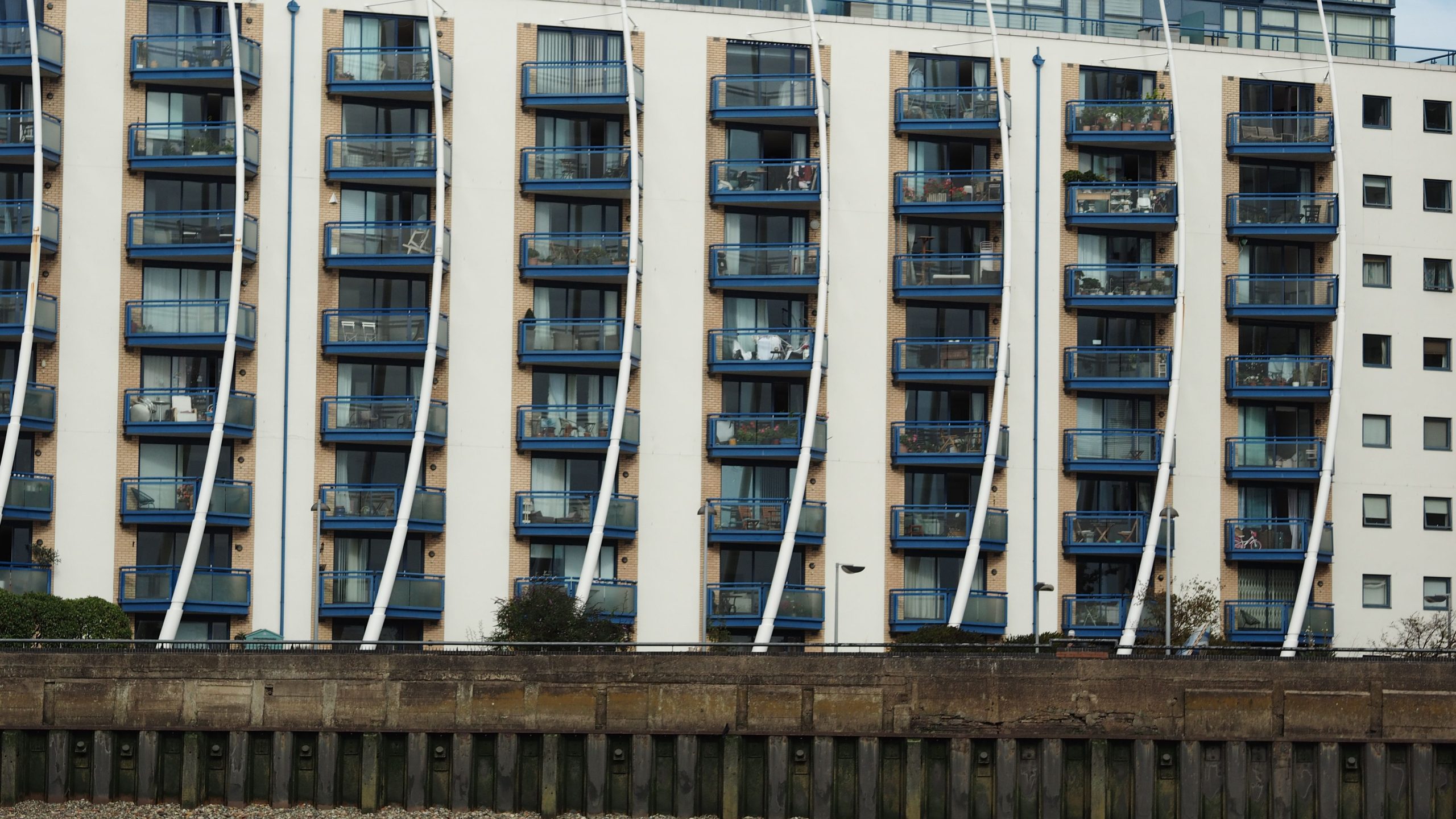 Balcony Fire Safety Regulations in the UK: What Property Owners and Landlords Need to Know Contemporary apartment block with blue balconies and unique facade design